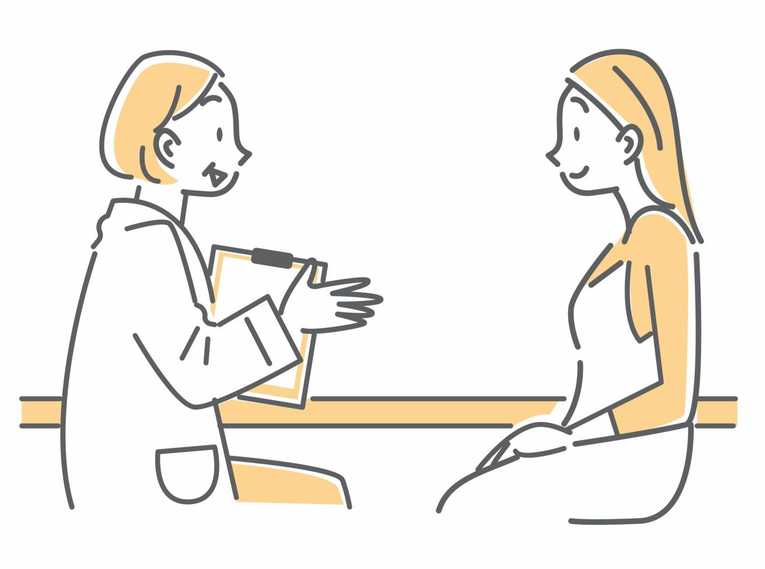 専門家が、座って、目の前に座っている女性に対し、経済的DVについて相談に乗っている絵